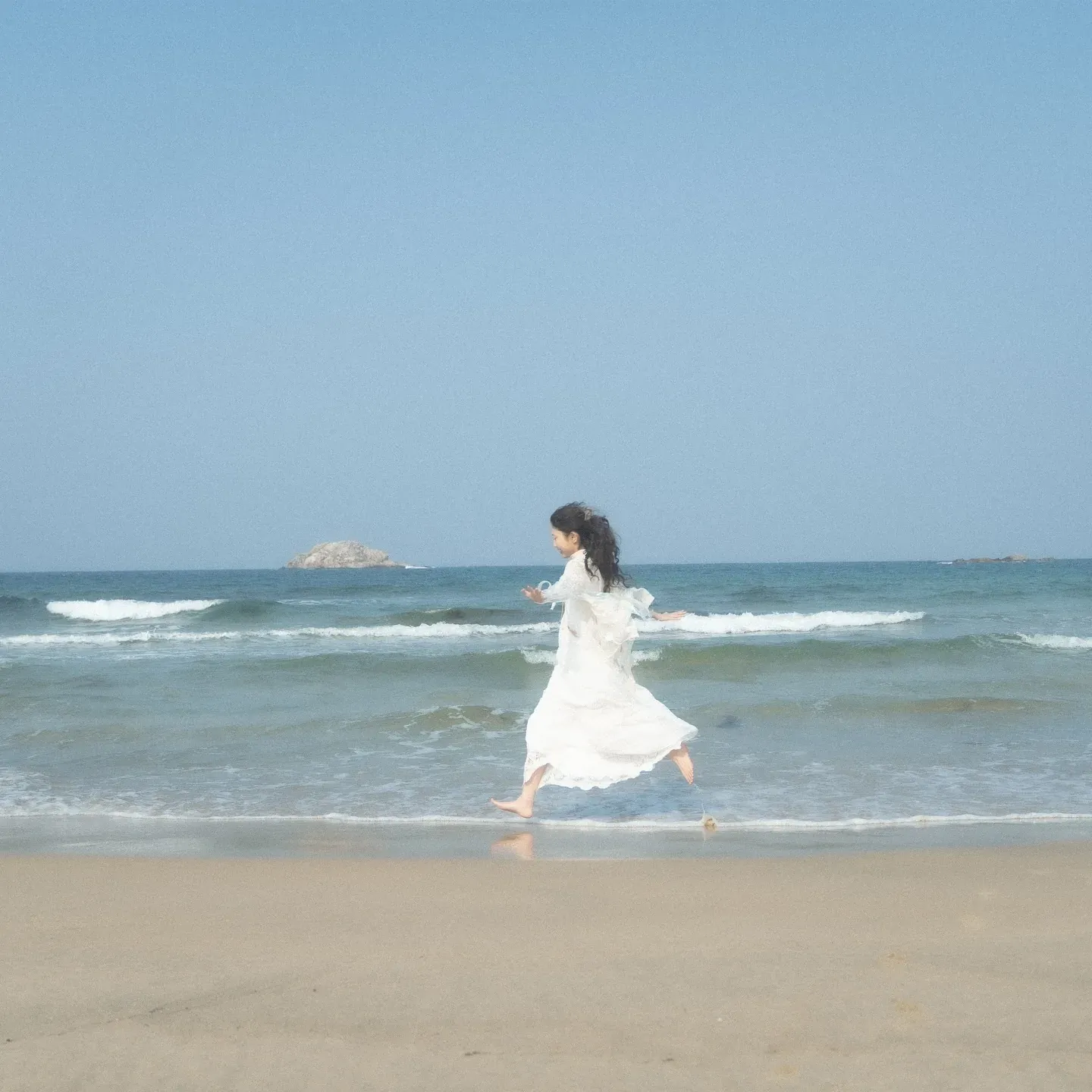 Gyuri running along a distant beach